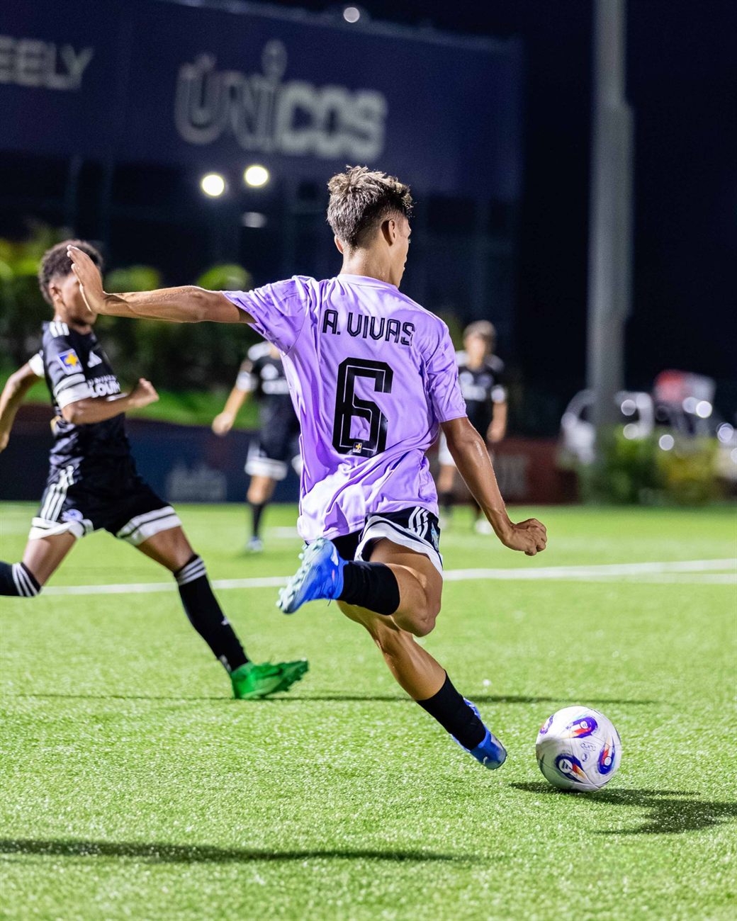 Angel Vivas de espaldas, con el 6 en la camiseta, por golpear la pelota