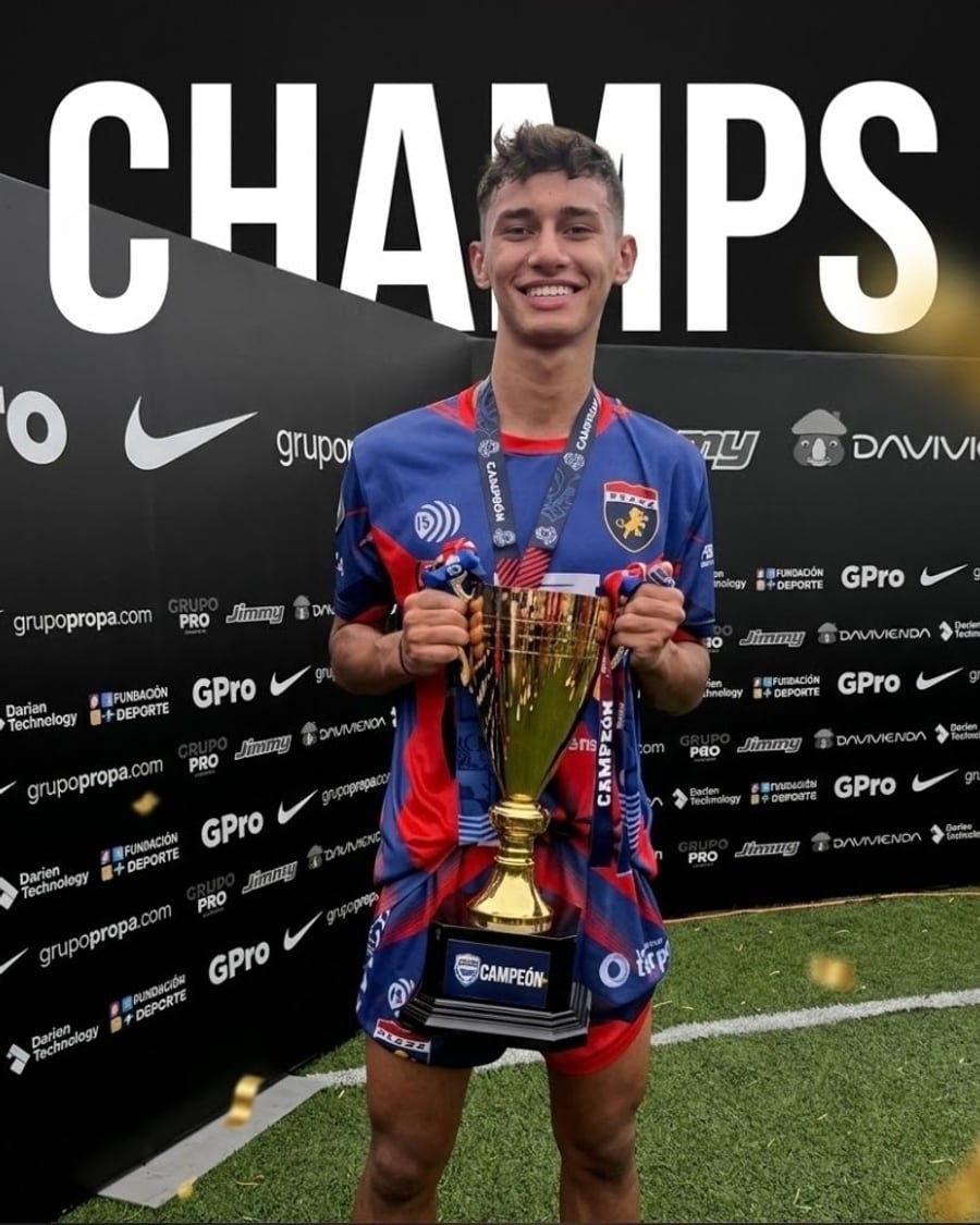 Angel Vivas levanta la copa de campeon con la camiseta roja y azul
